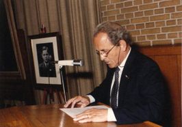 Dokter P.J.A. Lenglet tijdens de herdenking in 1984 van de gebeurtenissen op 6 september 1944. Naast hem een foto van Joop Hoffmans (SALHA, fotonr. WAA 43502).